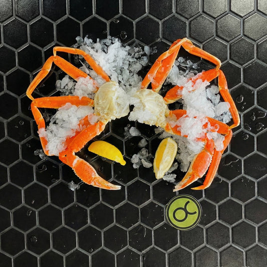 Quebec snow crab with ice and lemon on small black hexagonal tiles with the O&C logo